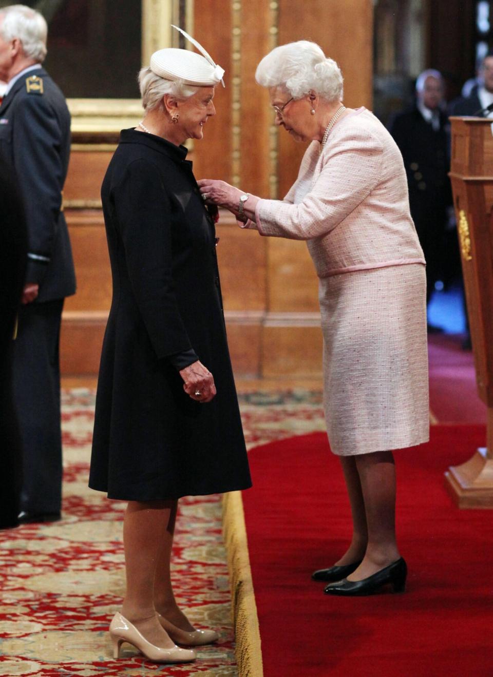 Angela Lansbury being made a Dame Commander by Queen Elizabeth II during an Investiture ceremony at Windsor Castle, Berkshire
