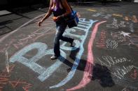 A woman walks across a chalk drawing of the Bernie Sanders campaign logo outside the Wells Fargo Center on the first day of the Democratic National Convention in Philadelphia, Pennsylvania. REUTERS/Dominick Reuter