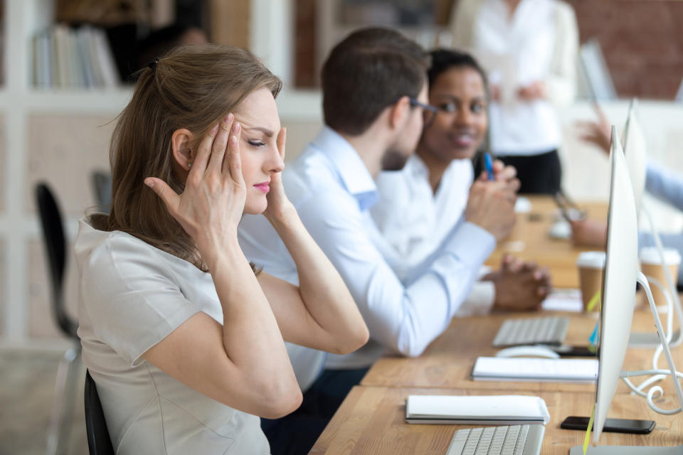 Tired overworked businesswoman massaging, touching temples, feeling headache after working long hours with computer, suffering from pain at workplace, having health problem