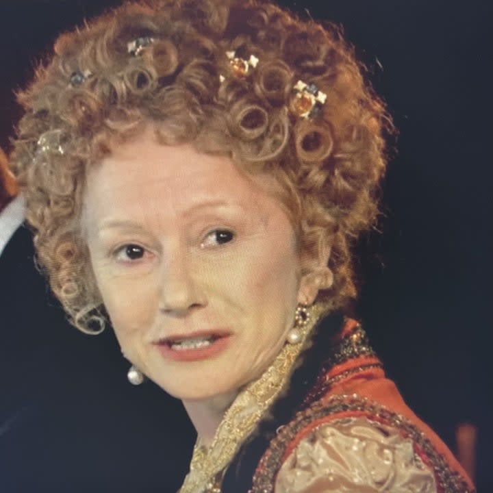 Helen Mirren as Elizabeth I wearing a red cape