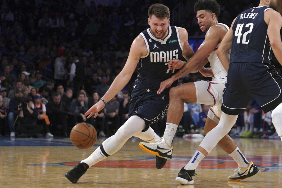 Dallas Mavericks guard Luka Doncic, left, drives around New York Knicks guard Quentin Grimes, center, during the first quarter of an NBA basketball game, Saturday, Dec. 3, 2022, in New York. (AP Photo/Bebeto Matthews)