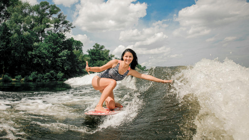 woman wakeboarding on wave down the river