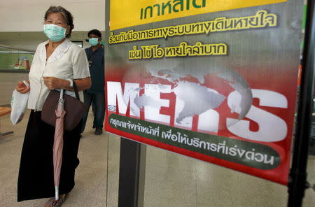A woman wearing a mask walks past an information banner on Middle East Respiratory Syndrome (MERS) at the entrance of Bamrasnaradura Infectious Diseases Institute at a hospital in Nonthaburi province, on the outskirts of Bangkok, Thailand, June 19, 2015. REUTERS/Chaiwat Subprasom
