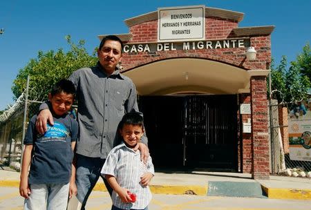 Salvadoran migrant Epigmenio Centeno and his sons, nine-year old Axel Jaret (L) and three-year old Steven Atonay, pose for a photograph outside the shelter House of the Migrant, after Epigmenio decided to stay with his children in Mexico due to U.S. President Donald Trump's child separation policy, in Ciudad Juarez, Mexico June 19, 2018. The sign above the entrance reads "Welcome migrant brothers and sisters." REUTERS/Jose Luis Gonzalez