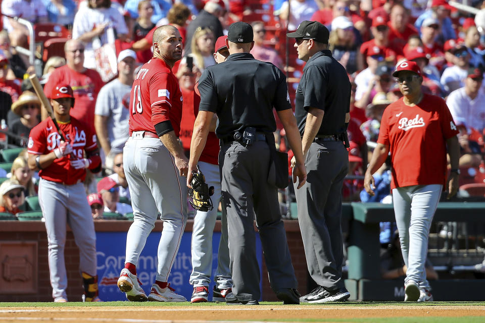 Cincinnati Reds' Joey Votto, front left, argues with the umpires after being ejected after the first inning of a baseball game against the St. Louis Cardinals, Sunday, Oct. 1, 2023, in St. Louis. (AP Photo/Scott Kane)