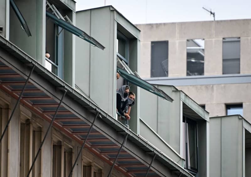 Pro-Palestinian demonstrators look out of the roof windows of the Institute of Social Sciences at Humboldt University. Activists have occupied rooms at Berlin's Humboldt University in support of the Palestinians and in protest against Israel. Soeren Stache/dpa