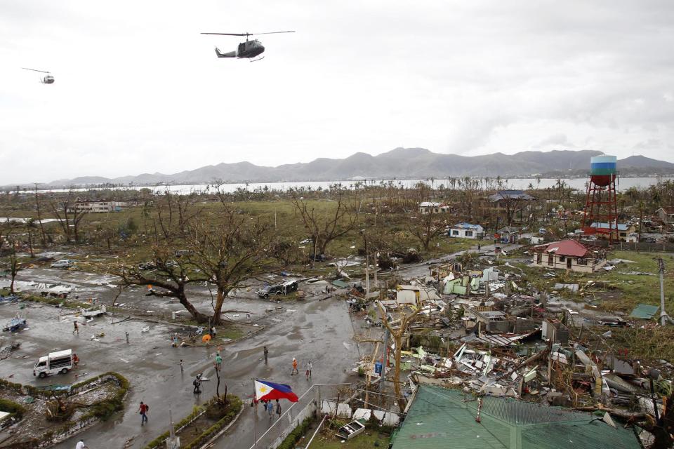 Helicopters hover over the damaged area after super Typhoon Haiyan battered Tacloban city, central Philippines, November 9, 2013. Possibly the strongest typhoon ever to hit land devastated the central Philippine city of Tacloban, killing at least 100 people, turning houses into rubble and leveling the airport in a surge of flood water and high wind, officials said on Saturday. The toll of death and damage from Typhoon Haiyan on Friday is expected to rise sharply as rescue workers and soldiers reach areas cut off by the massive, fast-moving storm which weakened to a category 4 on Saturday. REUTERS/Romeo Ranoco (PHILIPPINES - Tags: DISASTER ENVIRONMENT TPX IMAGES OF THE DAY)