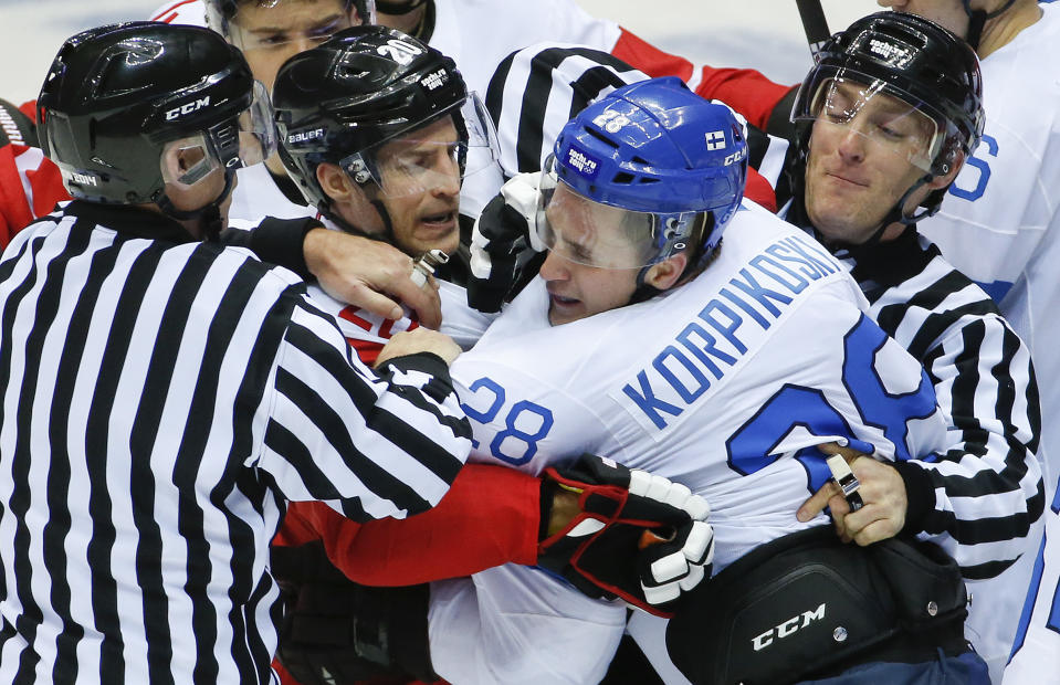 Referees break up a scuffle between Austria forward Daniel Welser (20) and Finland forward Lauri Korpikoski in the third period of a men's ice hockey game at the 2014 Winter Olympics, Thursday, Feb. 13, 2014, in Sochi, Russia. (AP Photo/Mark Humphrey)