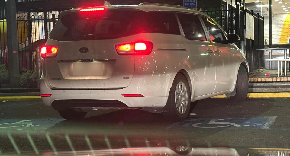 White Kia Carnival stopped in disabled parking bay McDonald's