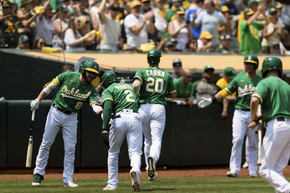 Oakland Athletics' Starling Marte (2) celebrates with Oakland Athletics' Jed Lowrie (8) after scoring against the Texas Rangers during the third inning of a baseball game in Oakland, Calif., Saturday, Aug. 7, 2021. (AP Photo/John Hefti)