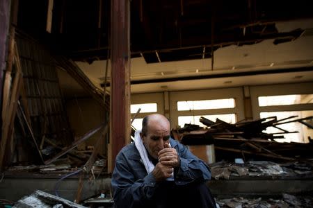 Kurdish worker Suleyman Hasgul smokes a cigarette during a break at a demolition site in Chiba east of Tokyo, October 21, 2015. REUTERS/Thomas Peter