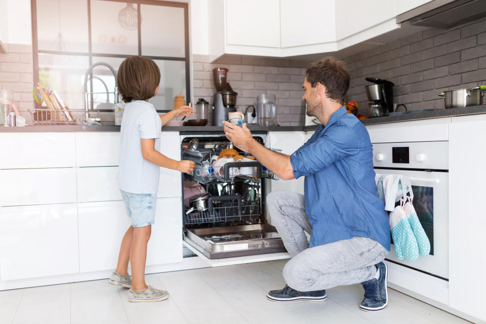 Father and son loading dishwasher together