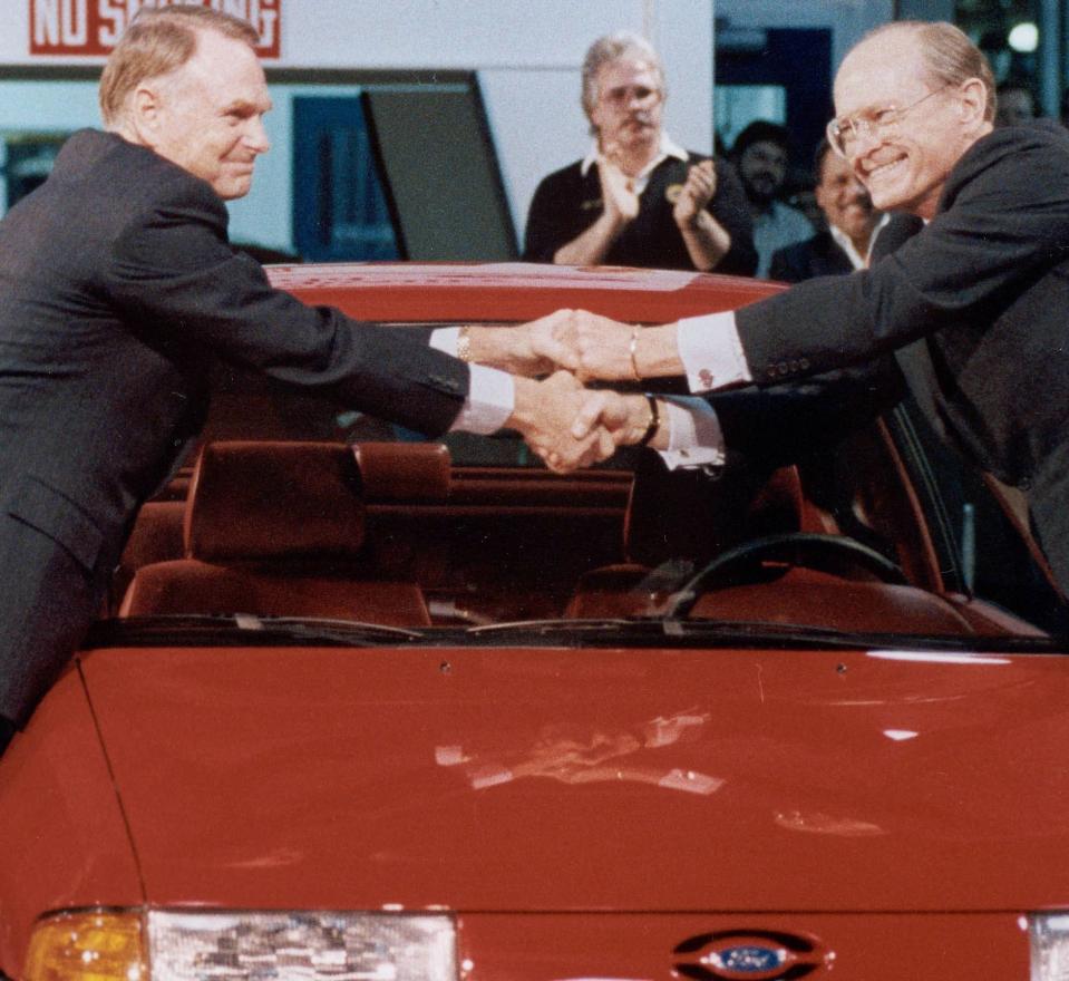 Harold Poling, left, shakes hands with Don Petersen. Poling succeeded Petersen as CEO at Ford Motor Co.