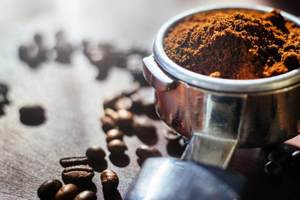 Fresh ground coffee and espresso beans in back light.