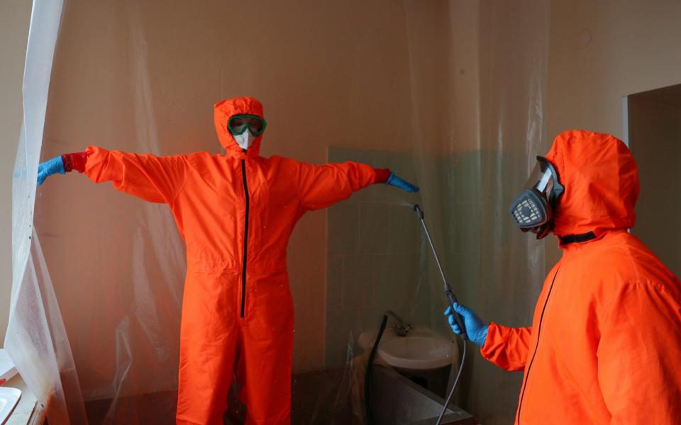 Medical workers disinfect their protective suits before leaving the red zone of a COVID-19 facility - rik Romanenko\\TASS