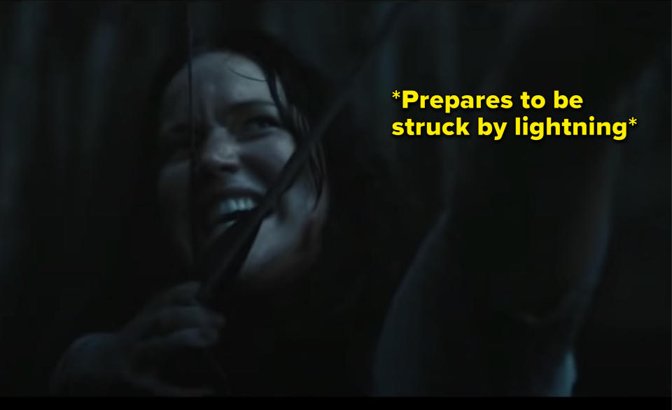 Katniss pulling her arrow back with the caption "prepares to be struck by lightning"