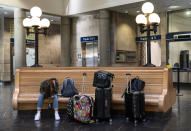 A passenger waits to board a train at the station in Providence, R.I., Friday, Nov. 20, 2020. With the coronavirus surging out of control, the nation's top public health agency pleaded with Americans not to travel for Thanksgiving and not to spend the holiday with people from outside their household. (AP Photo/David Goldman)