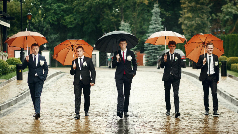 wedding groomsmen walking in rain