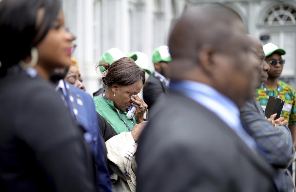 A woman wipes her eyes during a ceremony to return the mortal remains of Patrice Lumumba at the Egmont Palace in Brussels, Monday, June 20, 2022. On Monday, more than sixty one years after his death, the mortal remains of Congo's first democratically elected prime minister Patrice Lumumba will be handed over to his children during an official ceremony in Belgium. (AP Photo/Olivier Matthys)