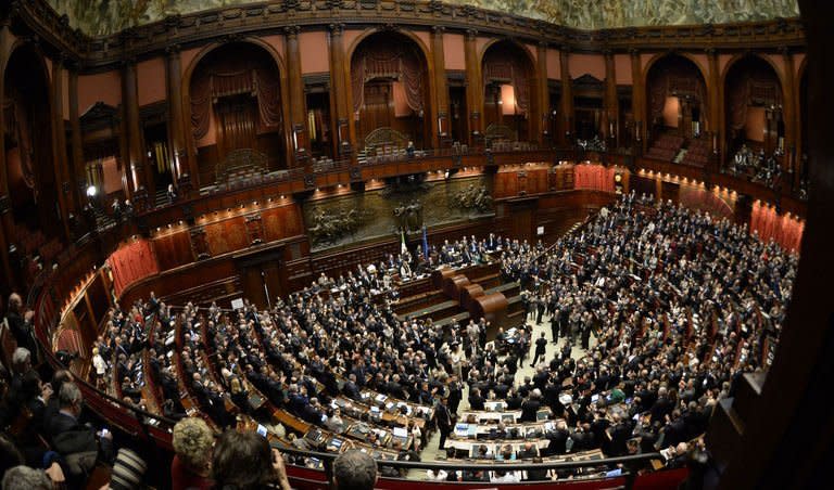 Italian deputies and senators applaud in the Italian Parliament in Rome on April 20, 2013, after Italian President Giorgio Napolitano was re-elected