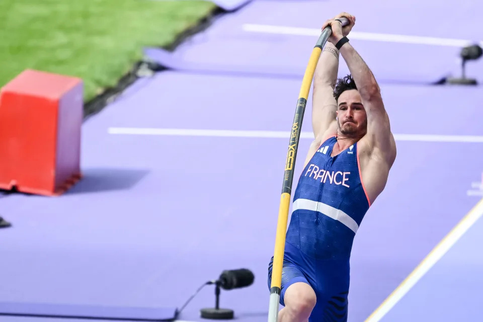 Renaud Lavillenie pole vaults in a "France" uniform at a track and field event