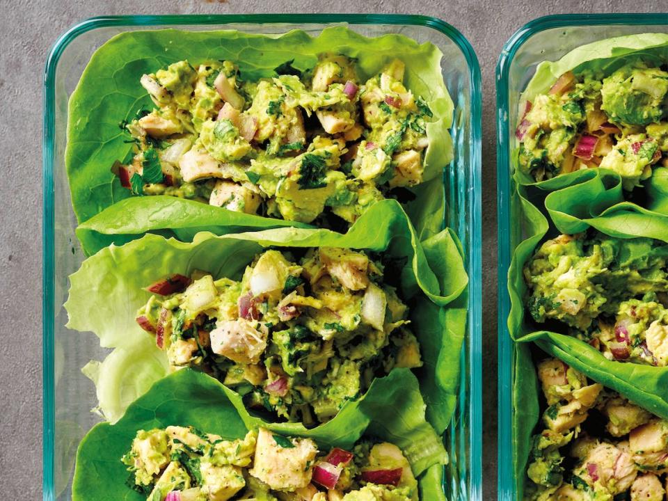 A glass dish of three chicken-avocado lettuce cups, seen from a bird's eye view.