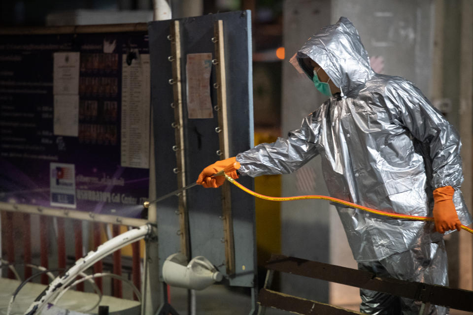 An army officer in a protective suit spraying disinfectant at the bus stop area in front of the department store at midnight as a preventing measure the spread of coronavirus on March 19, 2020 in Bangkok, Thailand. (Photo by Vachira Vachira/NurPhoto via Getty Images)