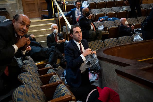 UNITED STATES - JANUARY 6: Rep. Jason Crow, D-Colo.,  and other members take cover as protesters attempt to disrupt the joint session of Congress to certify the Electoral College vote on Wednesday, January 6, 2021. (Photo By Tom Williams/CQ-Roll Call, Inc via Getty Images)
