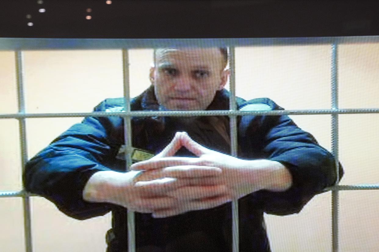 FILE - In this image provided by the Russian Federal Penitentiary Service, opposition leader Alexei Navalny appears on a video screen set up at Moscow City Court, on May 24, 2022. 