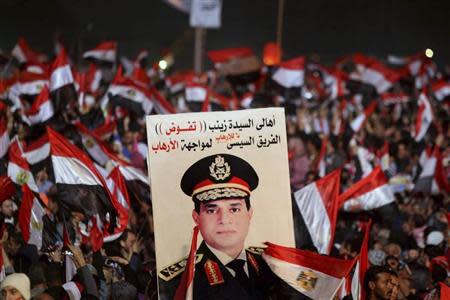 Supporters of Egypt's army chief General Abdel Fattah al-Sisi holds a poster of Sisi in Tahrir square in Cairo, on the third anniversary of Egypt's uprising, January 25, 2014. REUTERS/Mohamed Abd El Ghany