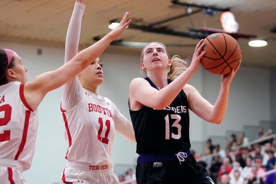 Holy Cross guard Bronagh Power-Cassidy (13) drives toward the basket as Boston University forward Caitlin Weimar (11) defends during the second half.