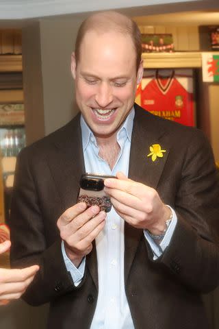 <p>Chris Jackson/Getty</p> Prince WIlliam enjoying something on a mobile phone during his visit to t The Turf pub in Wrexham, on March 1