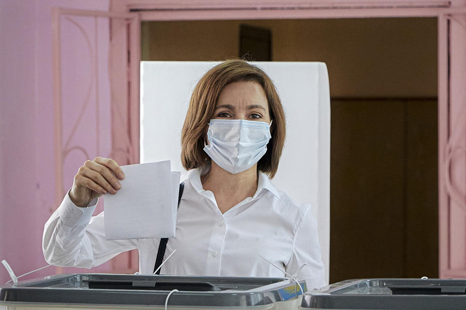 Moldova's President Maia Sandu prepares to cast her vote in a snap parliamentary election, in Chisinau, Moldova, Sunday, July 11, 2021. Moldovan citizens vote in a key snap parliamentary election that could decide whether the former Soviet republic fully embraces pro-Western reform or prolongs a political impasse with strong Russian influence. (AP Photo/Aurel Obreja)