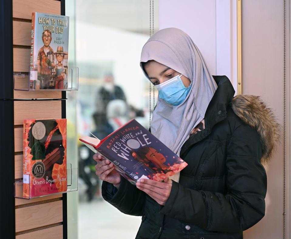 Framingham seventh grader Amira Lari looks for a book to read at the Fuller Middle School library,  Jan. 21, 2022. The city's school libraries have seen an increase in circulation during the pandemic.