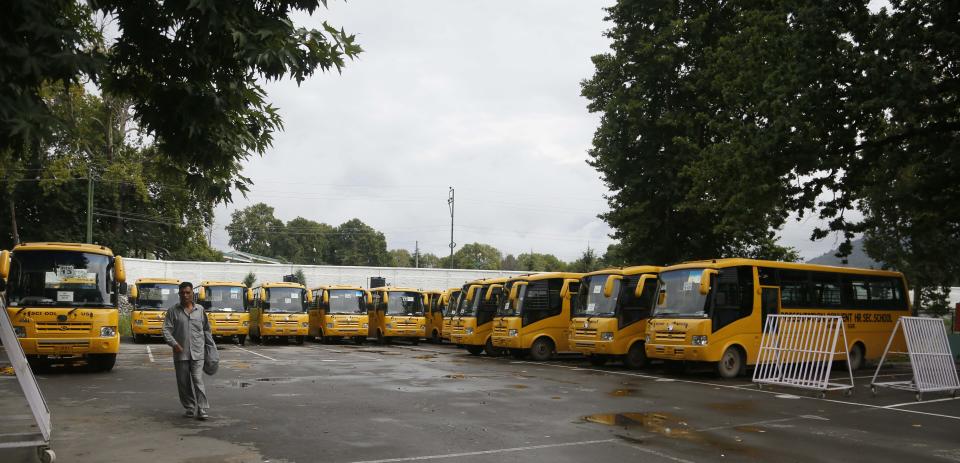 School buses are parked inside the premises of a deserted school compound in Srinagar, Indian controlled Kashmir, Monday, Aug. 19, 2019. Restrictions continue in much of Indian-administered Kashmir, despite India's government saying it was gradually restoring phone lines and easing a security lockdown that's been in place for nearly two weeks. (AP Photo/Mukhtar Khan)