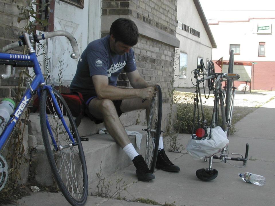 Mark Nicklawske fixes a flat tire in Shawano, about midway through our Mountain-Bay State Trail ride to go see a preseason Packers game at Lambeau Field.