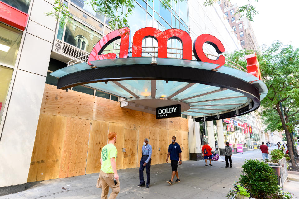 People walk outside the newly boarded AMC 34th Street 14 movie theater<span class="copyright">Noam Galai—Getty Images</span>