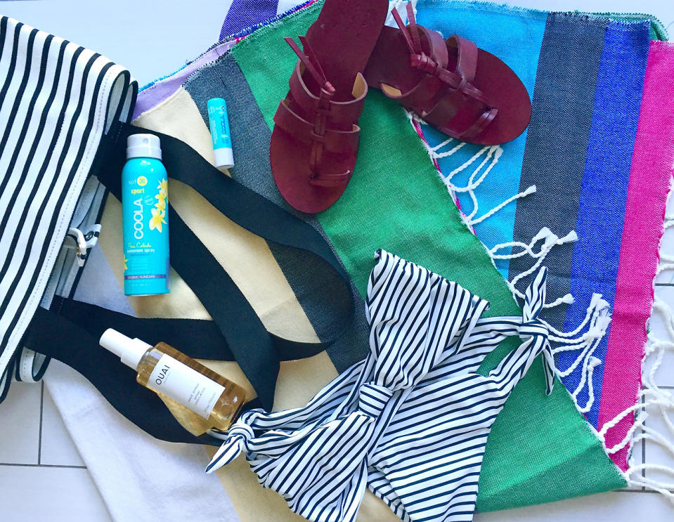 <p>Let's take a peek inside my beach bag. (Spoiler alert: It's full of stripes!) This oversized COS stripe canvas tote holds all my essentials, including a towel, Coola sunscreen, and my Ouai surf spray. My go-to outfit? A knotted bandeau bikini from Mikoh accented with burgundy Trademark sandals.</p> <p><strong>Shop the look:</strong> COS tote, similar styles <a rel="nofollow noopener" href="http://www.cosstores.com/us/Women/Bags_Purses" target="_blank" data-ylk="slk:cosstores.com;elm:context_link;itc:0;sec:content-canvas" class="link ">cosstores.com</a>. Coola Face SPF, $32; <a rel="nofollow noopener" href="http://shop.coolasuncare.com/classic-face-sunscreen-spf-30-cucumber-moisturizer" target="_blank" data-ylk="slk:coolasuncare.com;elm:context_link;itc:0;sec:content-canvas" class="link ">coolasuncare.com</a>. Coola Liplux SPF, $12; <a rel="nofollow noopener" href="http://shop.coolasuncare.com/liplux-lip-sunscreen-spf-30-original" target="_blank" data-ylk="slk:coolasuncare.com;elm:context_link;itc:0;sec:content-canvas" class="link ">coolasuncare.com</a>. Ouai Wave Spray, $26; <a rel="nofollow noopener" href="http://click.linksynergy.com/fs-bin/click?id=93xLBvPhAeE&subid=0&offerid=429865.1&type=10&tmpid=10002&RD_PARM1=http%253A%252F%252Fwww.sephora.com%252Fwave-spray-P406665&u1=iscvmiamiswimweek" target="_blank" data-ylk="slk:sephora.com;elm:context_link;itc:0;sec:content-canvas" class="link ">sephora.com</a>. Mikoh bikini top, $112; <a rel="nofollow noopener" href="https://shop.mikoh.com/collections/tops/products/carmel-top?variant=6942060609" target="_blank" data-ylk="slk:mikoh.com;elm:context_link;itc:0;sec:content-canvas" class="link ">mikoh.com</a>. Mikoh bikini bottom, $112; <a rel="nofollow noopener" href="https://shop.mikoh.com/collections/bottoms/products/valencia-bottom?variant=6941002561" target="_blank" data-ylk="slk:mikoh.com;elm:context_link;itc:0;sec:content-canvas" class="link ">mikoh.com</a>. Trademark sandals, call (646) 559-4945. </p>