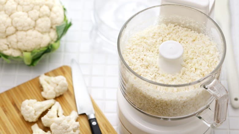 Cauliflower rice in food processor next to vegetable