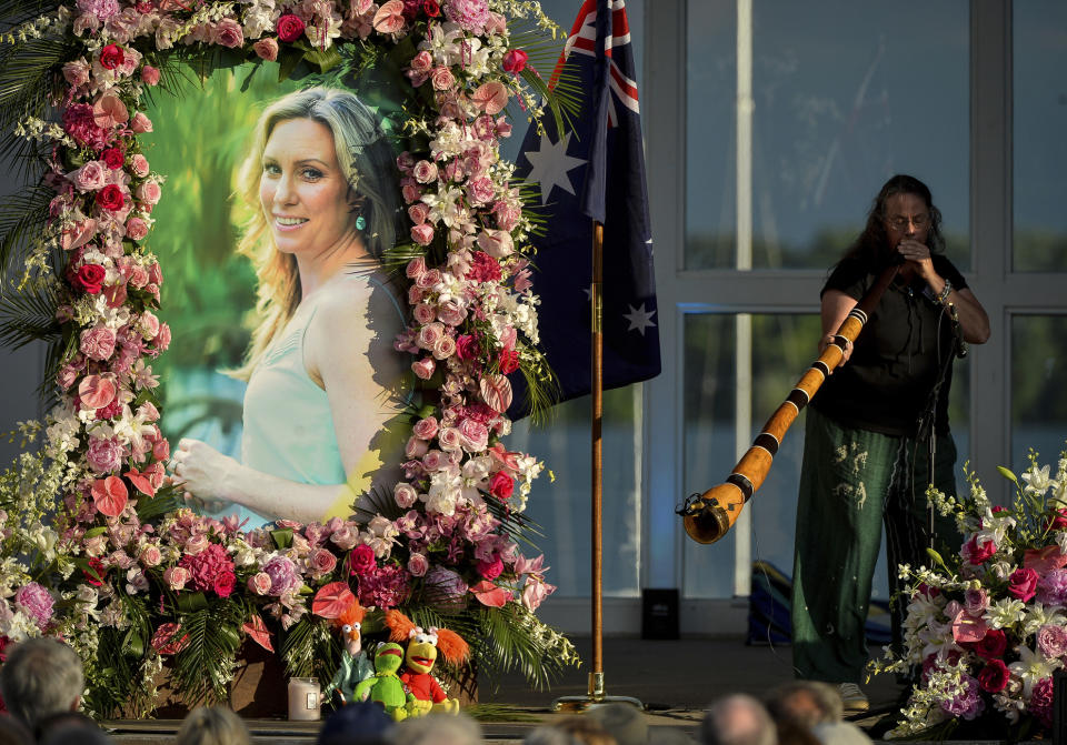 FILE - In this Aug. 11, 2017, file photo, Johanna Morrow plays the didgeridoo during a memorial service for Justine Ruszczyk Damond at Lake Harriet in Minneapolis. The city of Minneapolis is paying $20 million to settle a lawsuit over former police officer Mohamed Noor's fatal shooting of the unarmed Damond who approached his squad car after calling 911 to report a possible crime. Mayor Jacob Frey announced the settlement Friday, May 3, 2019, three days after a jury convicted Noor of murder and manslaughter in the 2017 death of Damond. Frey called the settlement "a way for our city to move forward." (Aaron Lavinsky/Star Tribune via AP, File)