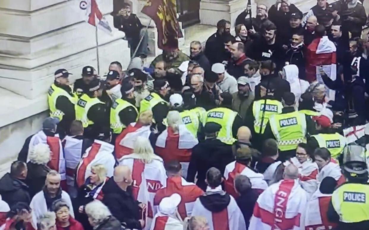 Protesters force their way throgh police cordon before the start of a St George's Day rally in Westminster