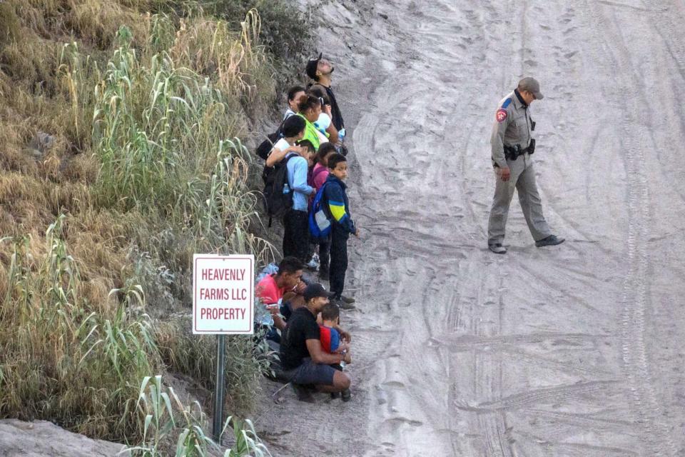 PHOTO: In this July 29, 2023, file photo, a Texas Department of Public Safety (DPS) trooper stands guard as migrant families surrender after crossing the Rio Grande river into the United States from Mexico, in Eagle Pass, Texas. (Adrees Latif/Reuters, FILE)