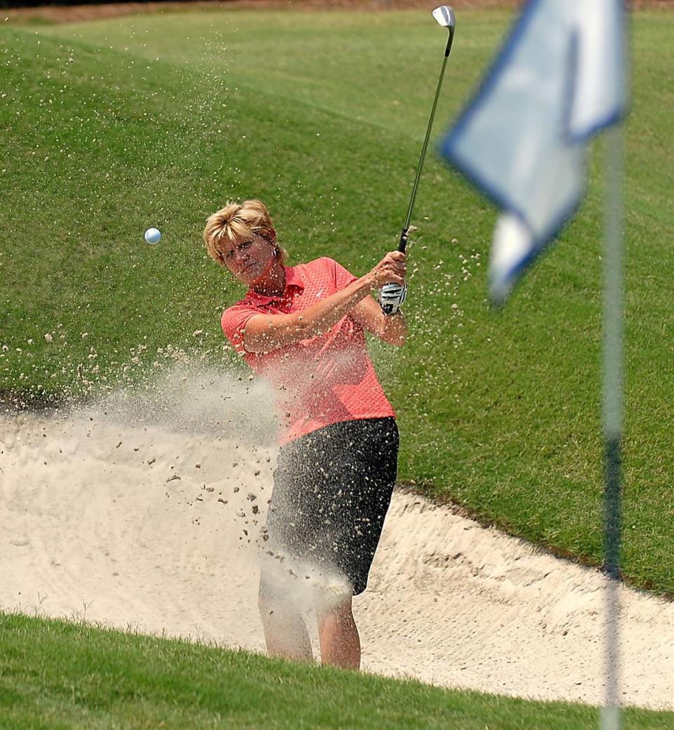 Dana Rader, shown in this 2006 photo, takes a shot at the green from a sandtrap.