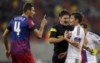 Lukasz Szukala of Steaua Bucharest (L) argues with Valentin Stocker of Basel (R) after receiving a yellow card from referee Matej Jug of Slovenia (C) during their Champions League soccer match at the National Arena in Bucharest October 22, 2013. REUTERS/Bogdan Cristel (ROMANIA - Tags: SPORT SOCCER)
