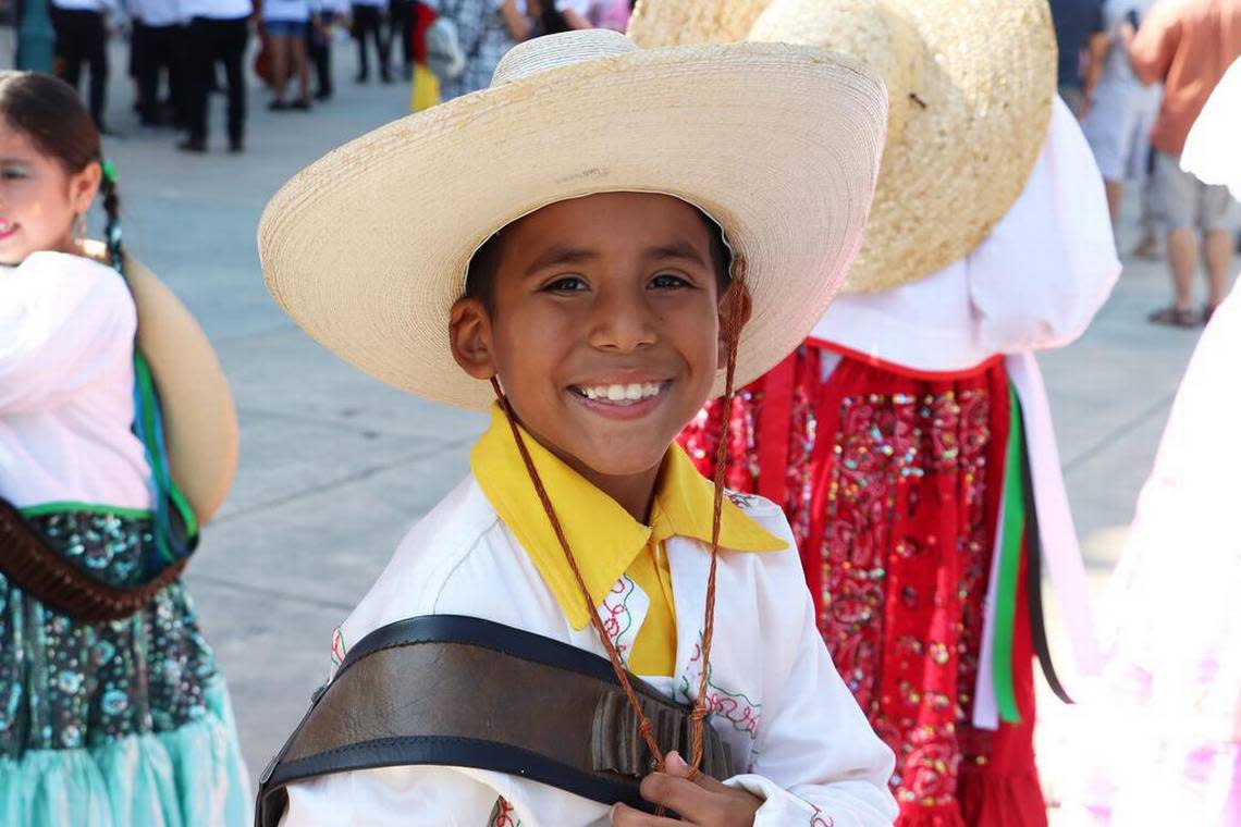 A folkloric dancer in Mexican Revolution attire smiles before taking part in the parade during the Sept. 17, 2022 Fiestas Patrias celebration in downtown Fresno.