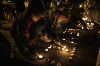 Children light candles as people gather for Kevin Peterson Jr., who was killed in Thursday's shooting with police involved, at a candlelight vigil in Vancouver, Wash., Friday, Oct. 30, 2020. The Clark County Sheriff's office has not released any details on the Thursday evening shooting in Hazel Dell, but a man told The Oregonian/OregonLive that his 21-year-old son was fatally shot by police. (AP Photo/Paula Bronstein)