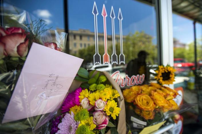 Flowers and cards form a makeshift memorial for shooting victim Jillian Johnson at Red Arrow Workshop in River Ranch in Lafayette, La., Friday, July 24, 2015. According to The Daily Advertiser, store co-owner Johnson was among the victims that died following the Thursday night shooting at the Grand 16 theater. (Paul Kieu/The Daily Advertiser via AP)