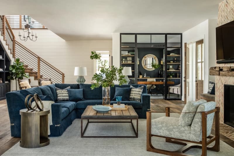 Living room with large blue velvet sofa and fireplace