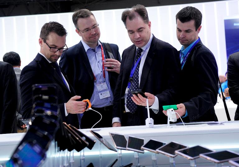 Visitors look at Samsung devices at the Mobile World Congress in Barcelona, on February 24, 2014