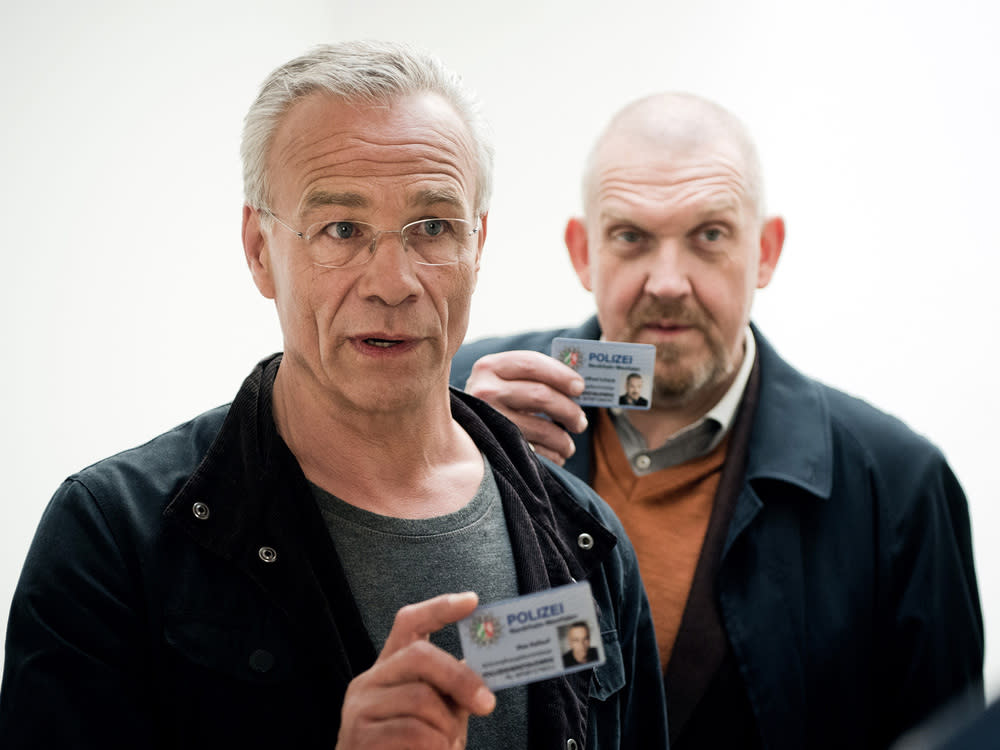 Szene aus dem "Tatort: Bausünden": Die Kommissare Max Ballauf (Klaus J. Behrendt, l.) und Freddy Schenk (Dietmar Bär) weisen sich aus (Bild: © WDR/Martin Valentin Menke)